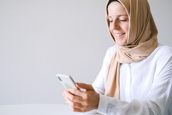 Seorang perempuan sedang zakat online - Zakat.or.id
