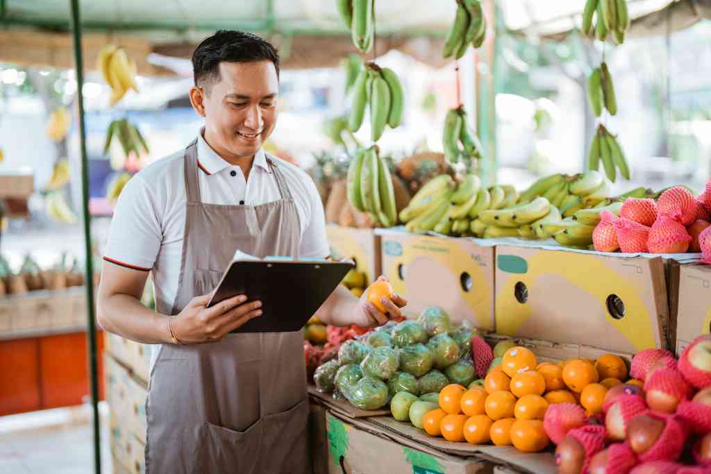 Ilustrasi penjual buah sedang melakukan kontrol kualitas buahnya