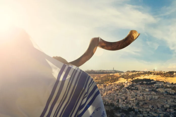 Man blowing the shofar with jerusalem city view