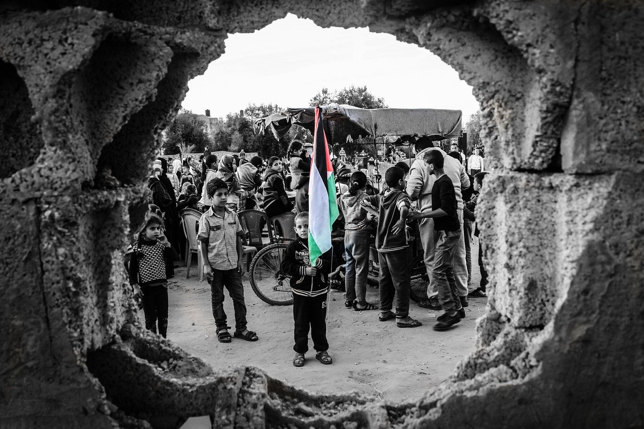 A boy holding a Palestinian flag in the crowd