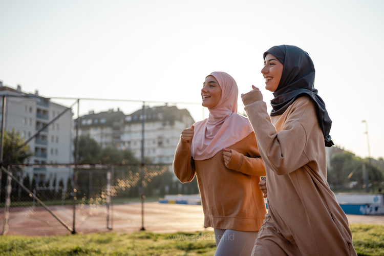 Dua orang muslimah sedang berolahraga sebagai bentuk ikhtiar menjadi pribadi yang sehat dan kuat